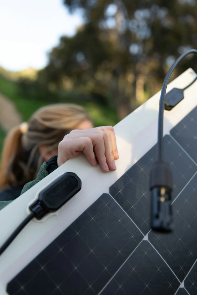 a person holding a solar panel with a charger attached to it
